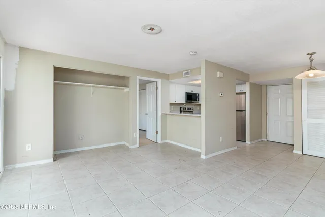a view of a kitchen with refrigerator and white cabinets