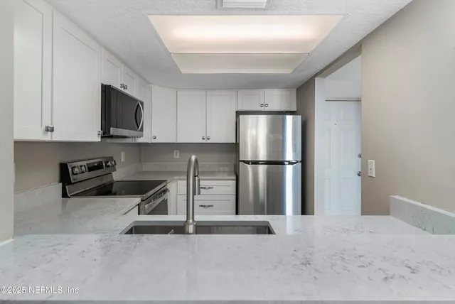 a kitchen with a refrigerator a stove and a sink