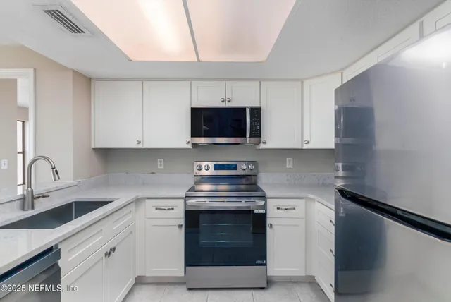 a kitchen with stainless steel appliances a stove a sink and a microwave