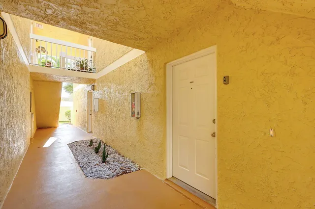 a view of a hallway with wooden floor and a bathroom