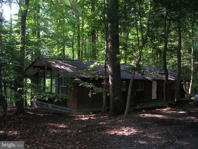 a view of a house with backyard and trees