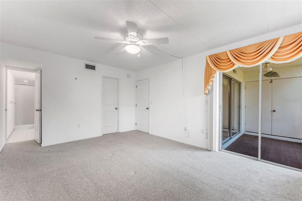 219 Cypress Court, Unit 219 Oldsmar, FL 34677 - Photo 17 of 34 an empty room with a chandelier fan and windows