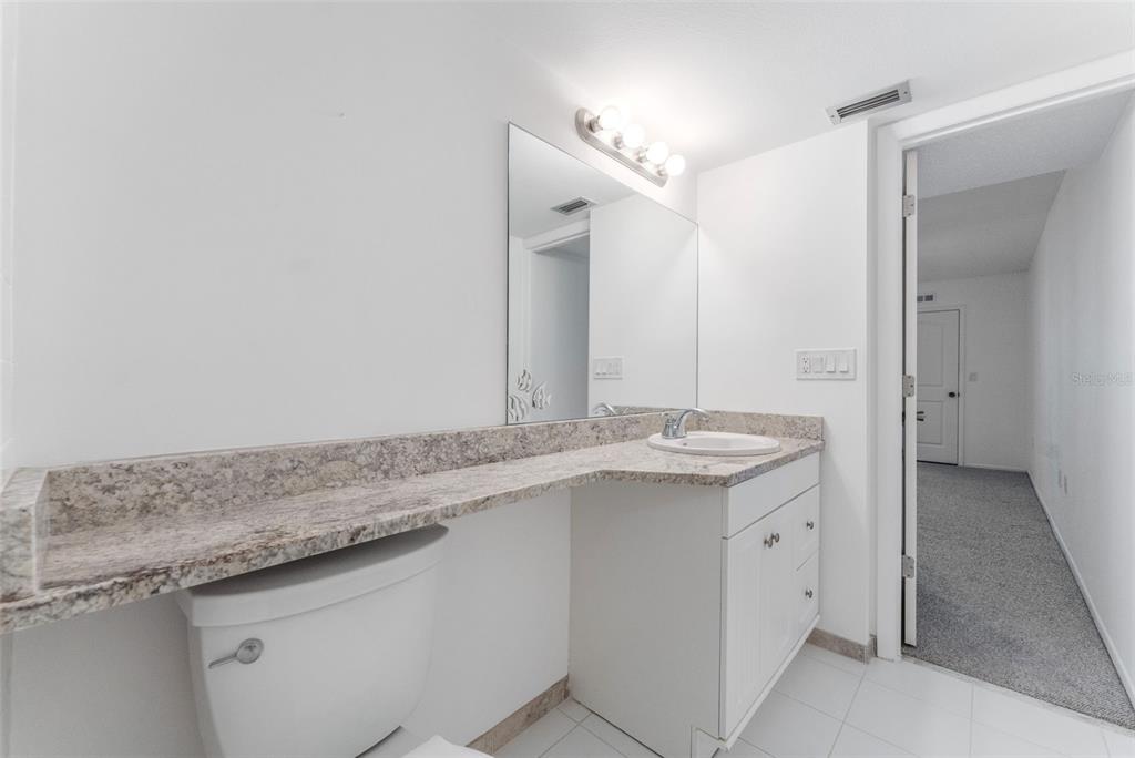 219 Cypress Court, Unit 219 Oldsmar, FL 34677 - Photo 19 of 34 a bathroom with a granite countertop sink and a mirror