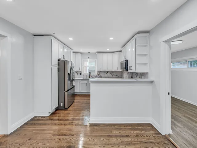 a kitchen with stainless steel appliances granite countertop a refrigerator a sink and a stove