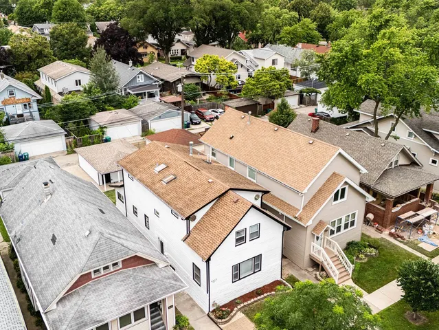 an aerial view of a residential houses with yard