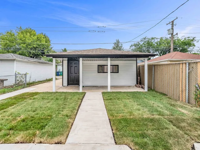 a front view of a house with a yard and potted plants