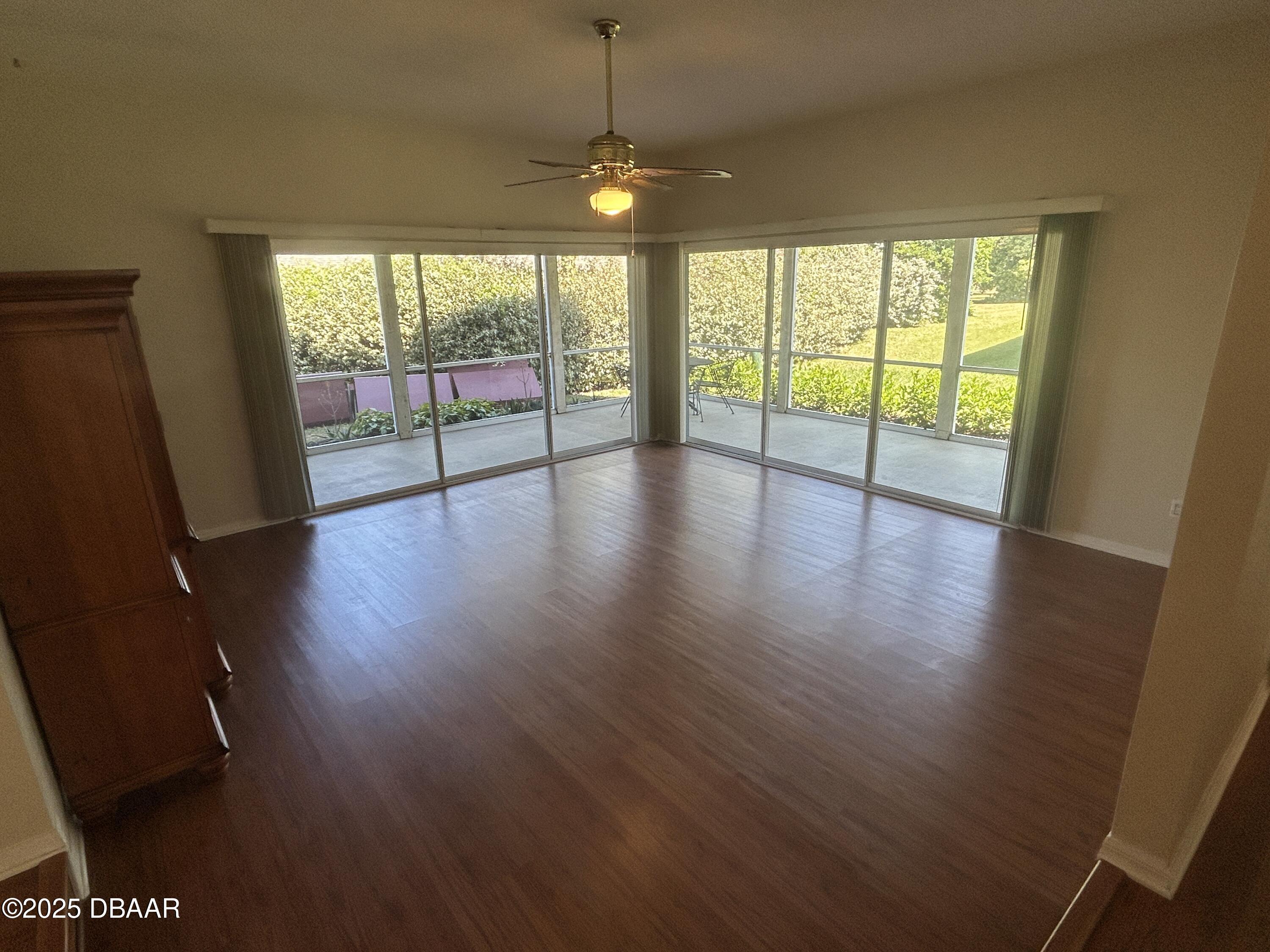 38 Magnolia Drive South, Unit S Ormond Beach, FL 32174 - Photo 2 of 12 a view of an empty room with wooden floor and a floor to ceiling window