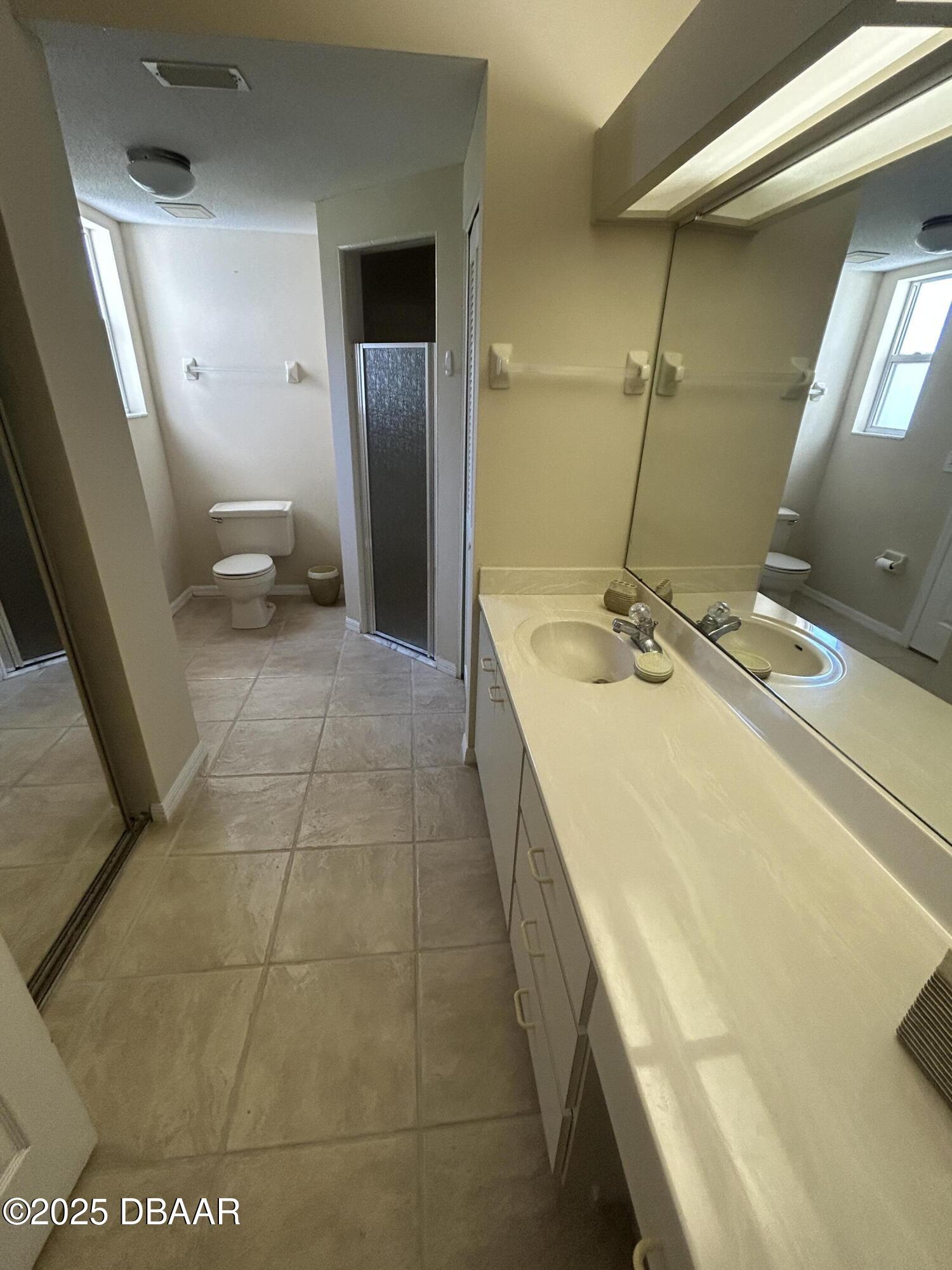 38 Magnolia Drive South, Unit S Ormond Beach, FL 32174 - Photo 6 of 12 a bathroom with a sink a toilet and a mirror