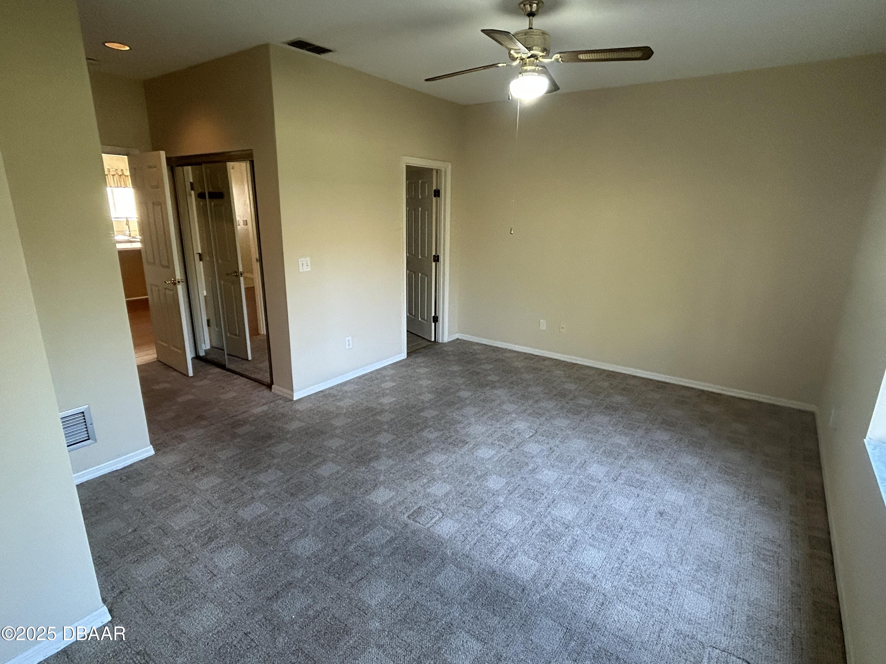 38 Magnolia Drive South, Unit S Ormond Beach, FL 32174 - Photo 7 of 12 an empty room with a ceiling fan and a bathroom