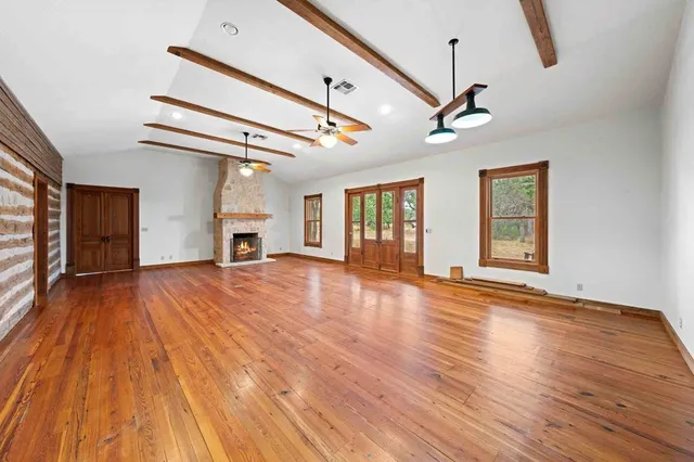 a view of empty room with wooden floor and fireplace