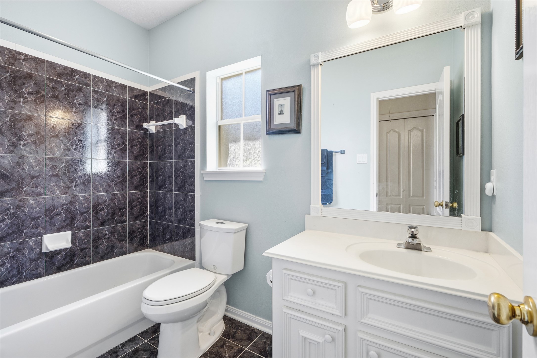 21719 Long Castle Drive Spring, TX 77388 - Photo 12 of 19 This bathroom features a single-sink vanity, a toilet, and a shower/tub combo, offering a clean, functional design with everyday comfort in mind.