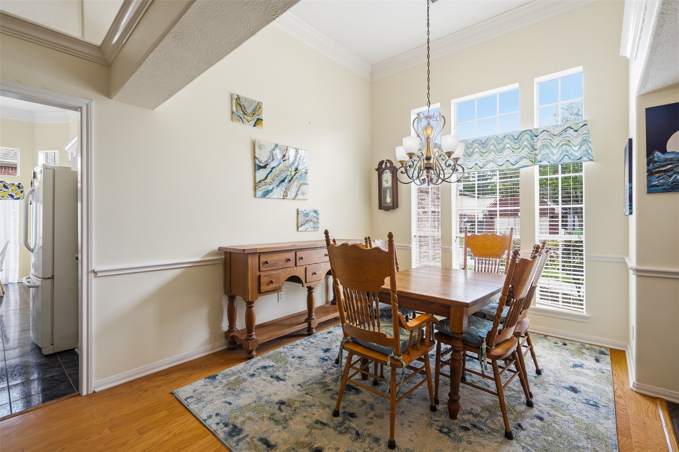 21719 Long Castle Drive Spring, TX 77388 - Photo 3 of 19 The dining room features a thick crown molding, multiple tall windows with privacy blinds, and rich wood flooring, creating a refined and inviting space ideal for hosting and entertaining.