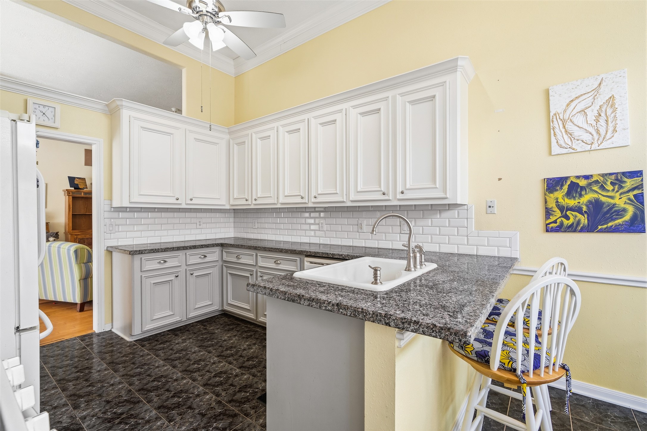 21719 Long Castle Drive Spring, TX 77388 - Photo 6 of 19 Fall in love with this beautifully designed kitchen featuring sleek gray cabinets, a classic white subway tile backsplash, stainless steel appliances, and a spacious island that anchors the room—perfect for cooking, gathering, and entertaining in style.