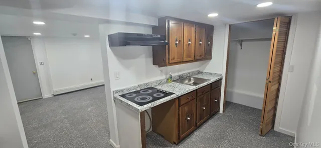 a kitchen with granite countertop a sink stove and refrigerator