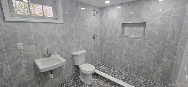 a bathroom with a toilet a sink a shower and a window