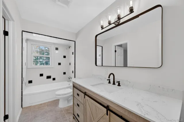 a bathroom with bathtub and window