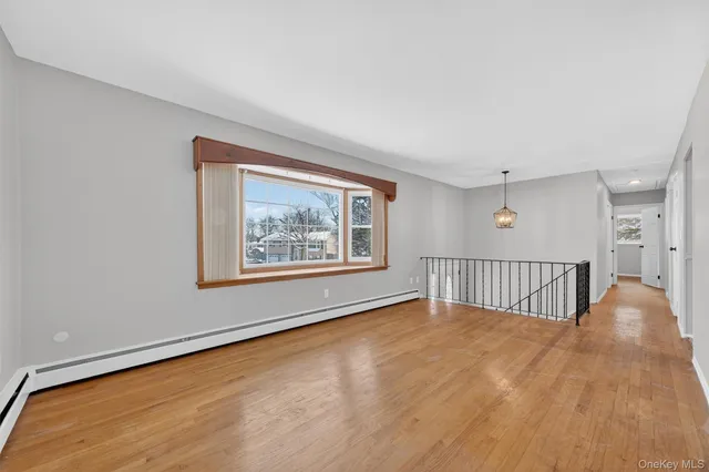 a view of an empty room with a window and a ceiling fan