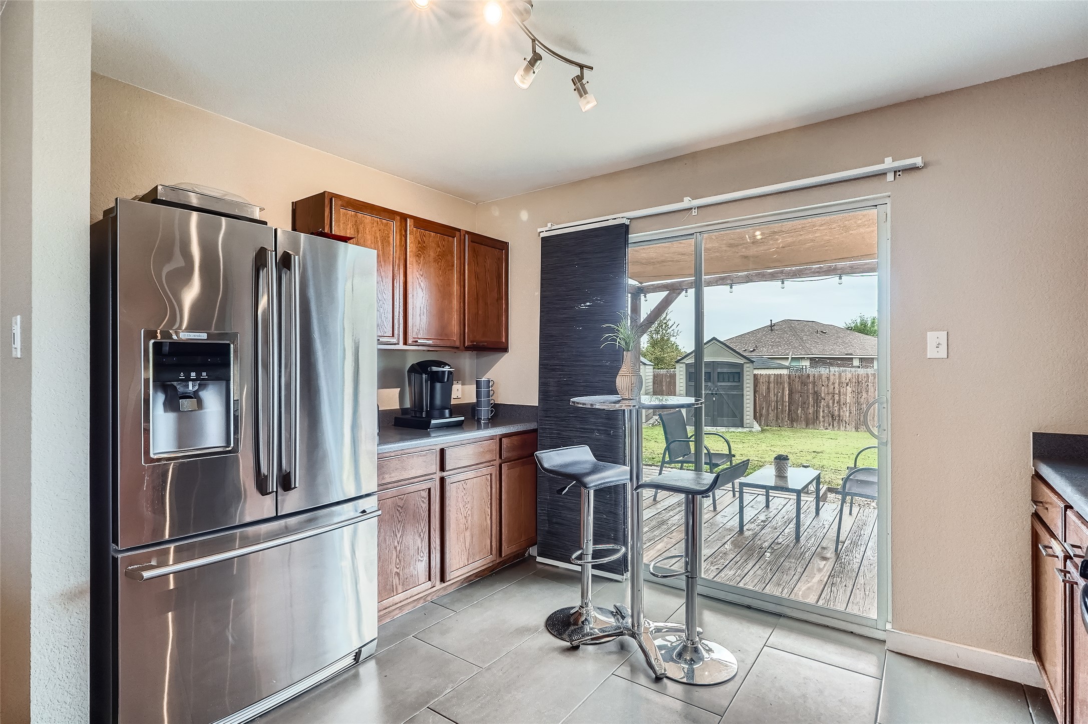 18021 Prairie Verbena Lane Elgin, TX 78621 - Photo 7 of 33 Stainless steel appliances complement rich cabinetry, opening to a deck and green yard.