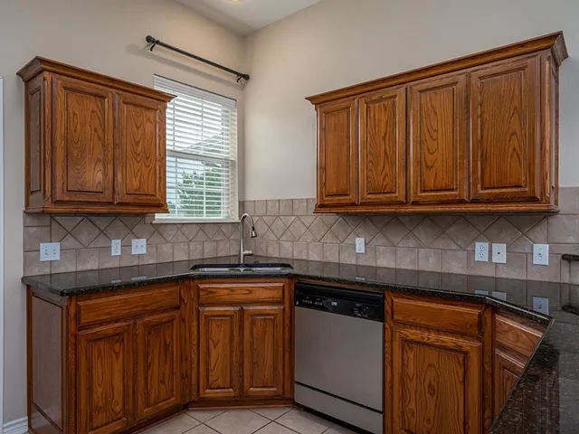a kitchen with stainless steel appliances granite countertop wooden cabinets and a sink