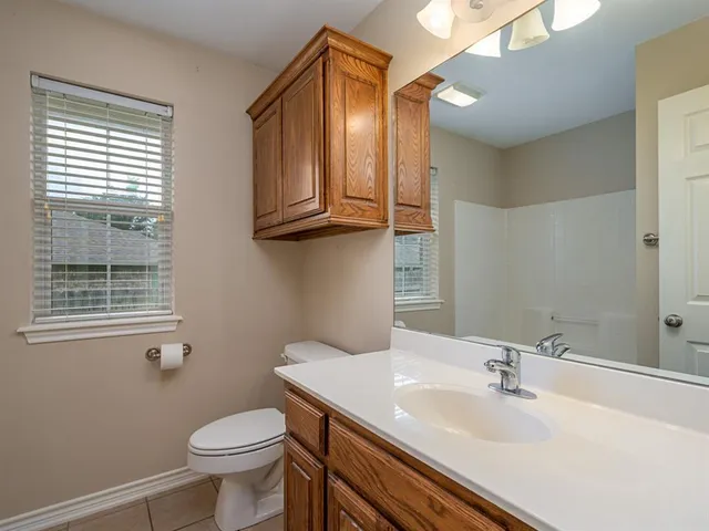 a bathroom with a sink a toilet and mirror