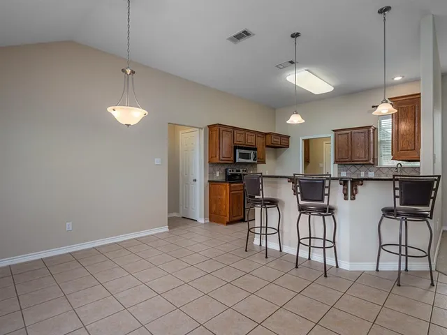 a open kitchen with cabinets and stainless steel appliances