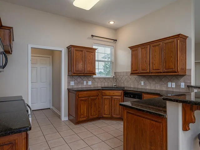a kitchen with stainless steel appliances granite countertop a sink stove and cabinets