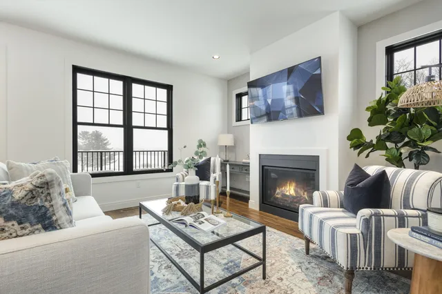 a living room with furniture a fireplace and windows