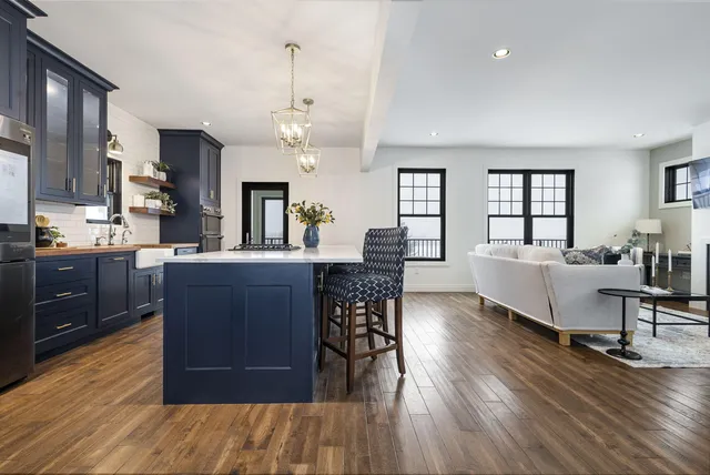 a large living room with a dining table wooden floor and a view of kitchen