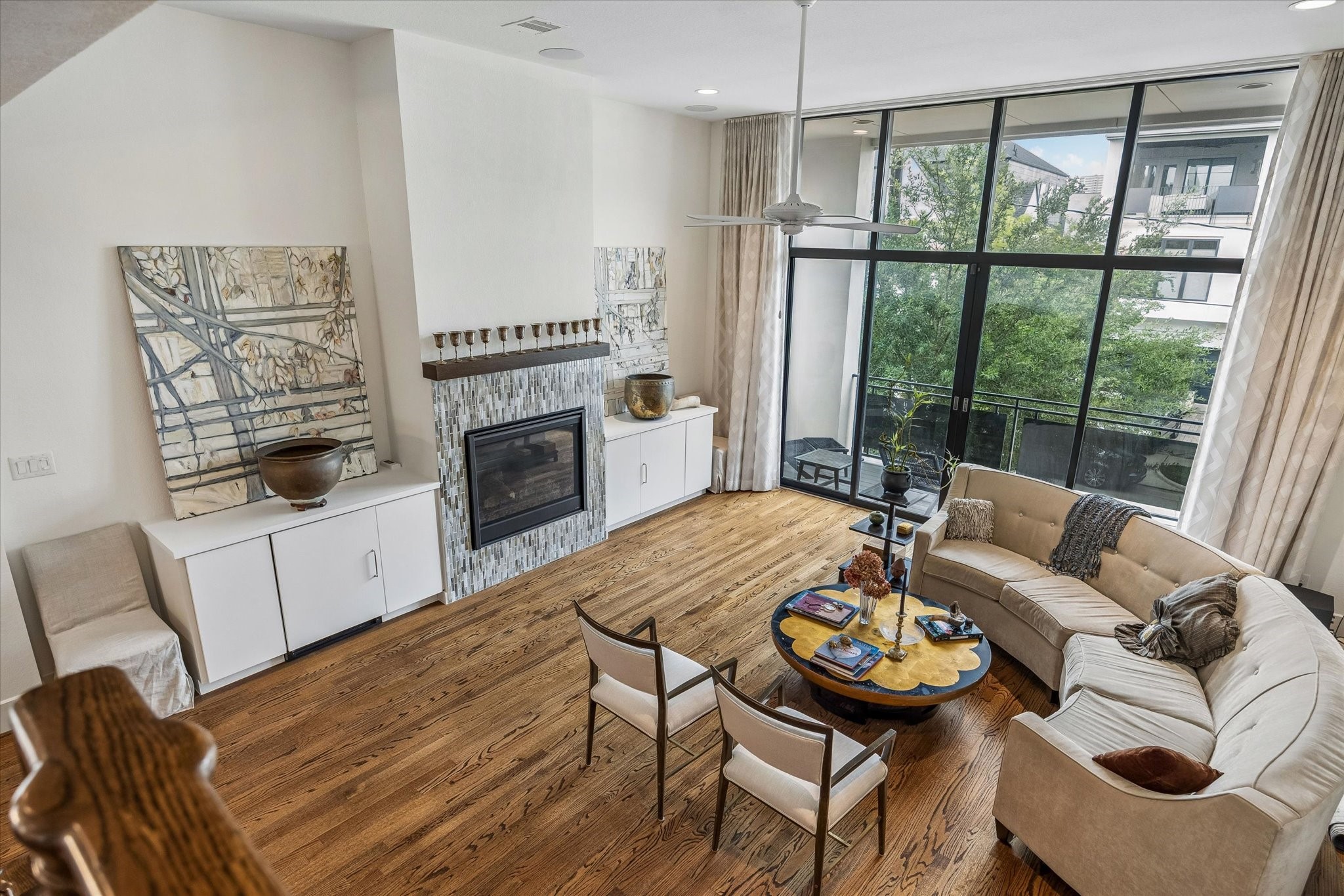 1526 Vermont Street Houston, TX 77006 - Photo 15 of 39 Living room filled with natural light, featuring soaring ceilings, expansive windows, and a covered balcony overlooking the trees.