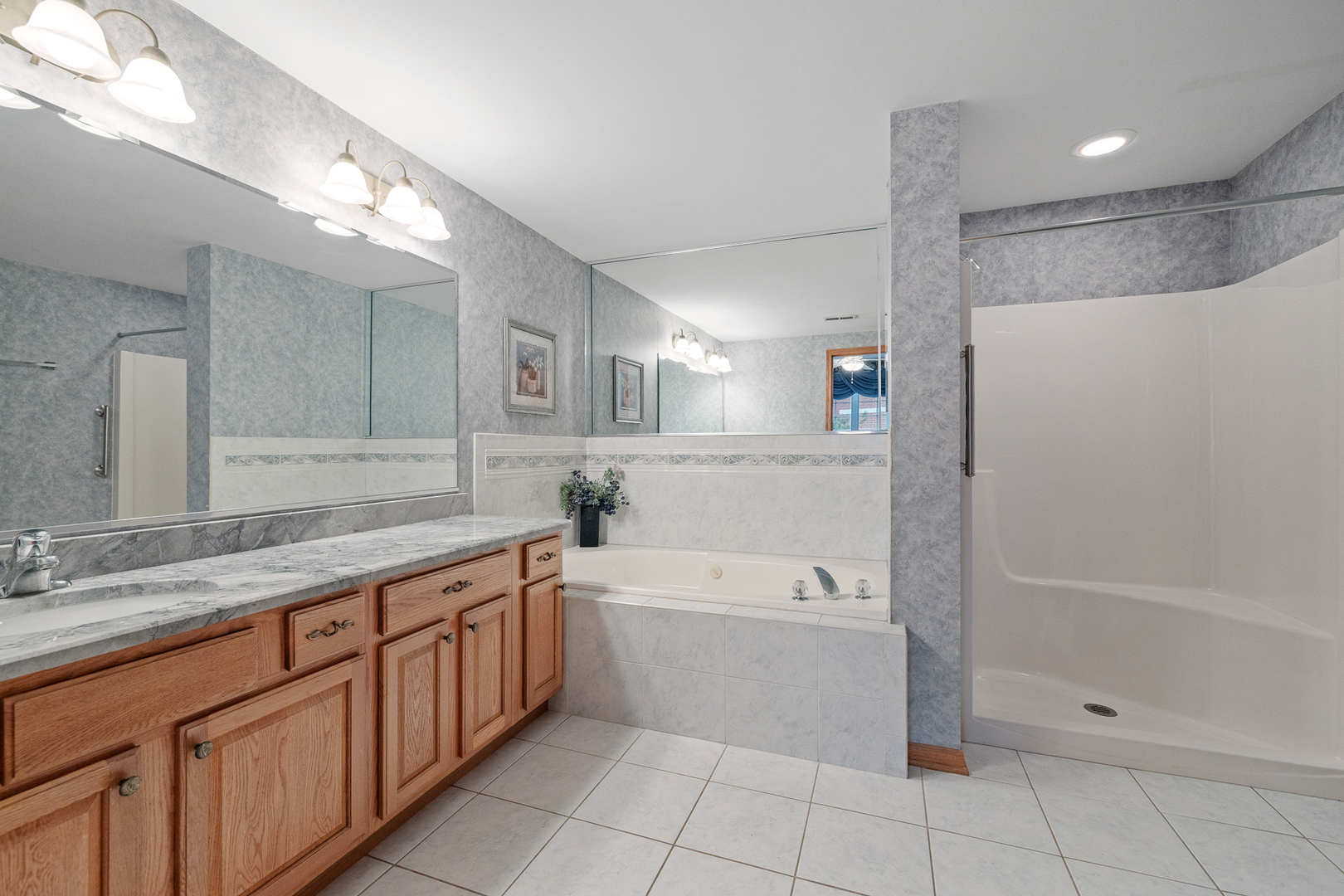 7912 Trinity Circle, Unit 1NW Tinley Park, IL 60487 - Photo 13 of 20 a spacious bathroom with a granite countertop sink a toilet mirror and bathtub