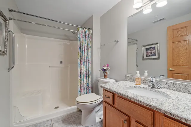 a bathroom with a granite countertop sink toilet and shower