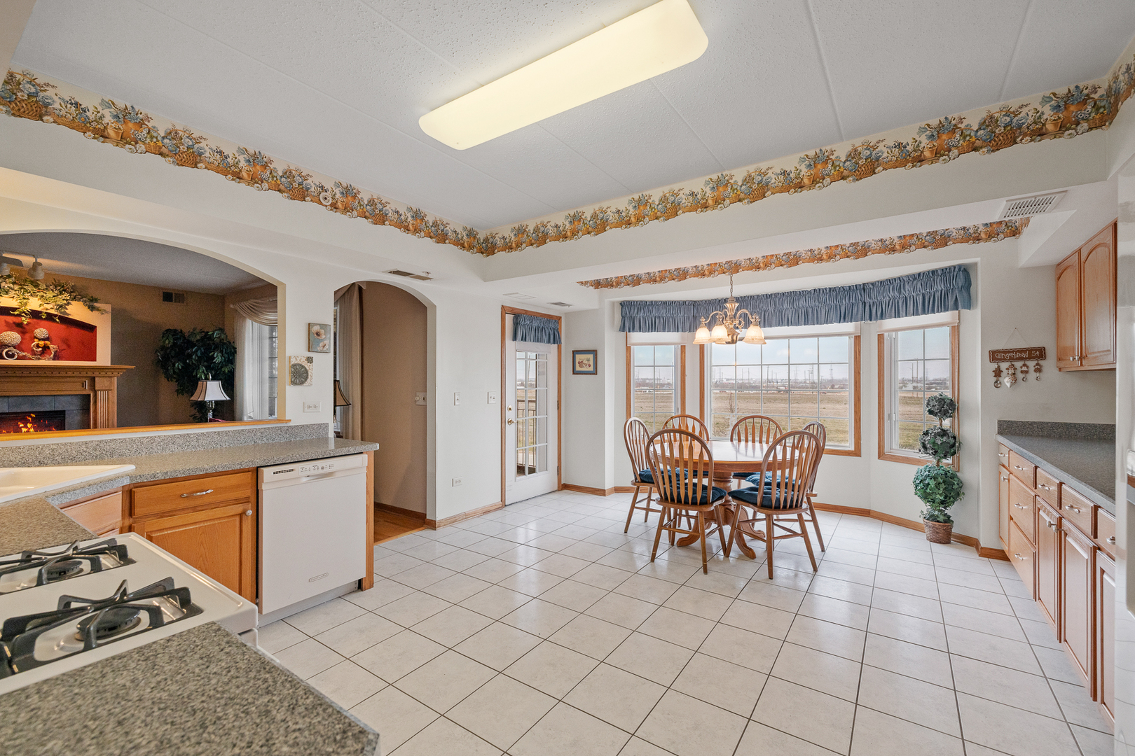 7912 Trinity Circle, Unit 1NW Tinley Park, IL 60487 - Photo 8 of 20 a dining hall with stainless steel appliances granite countertop a stove and white cabinets next to a window