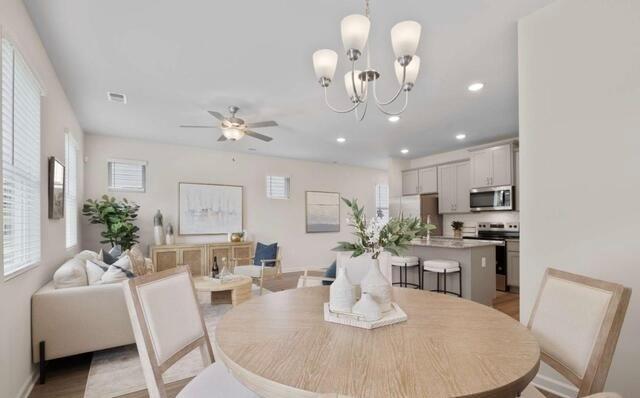 1290 Harmony Rdg Court Jonesboro, GA 30238 - Photo 13 of 29 a dining room with wooden floor a chandelier a glass table and chairs