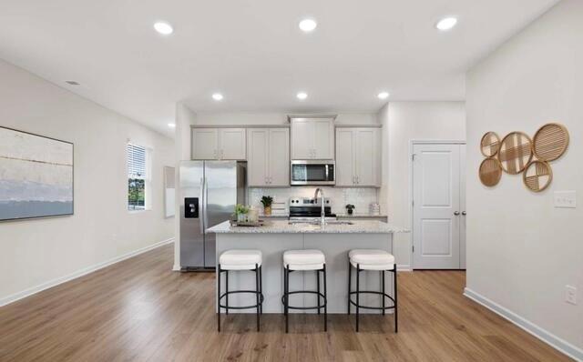 1290 Harmony Rdg Court Jonesboro, GA 30238 - Photo 5 of 29 a kitchen with stainless steel appliances granite countertop a dining table chairs refrigerator and microwave