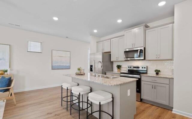 1290 Harmony Rdg Court Jonesboro, GA 30238 - Photo 6 of 29 a kitchen with stainless steel appliances kitchen island granite countertop a sink cabinets and wooden floor