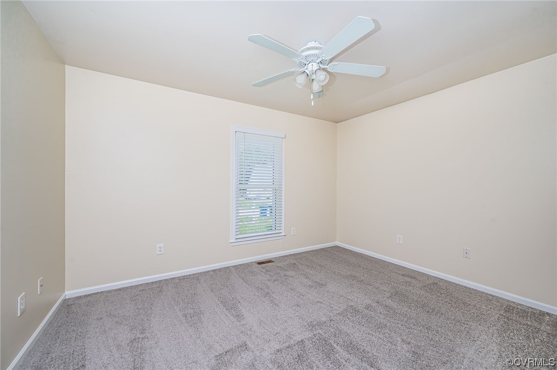 3741 Harrow Drive Chester, VA 23831 - Photo 17 of 37 an empty room with a chandelier fan and windows