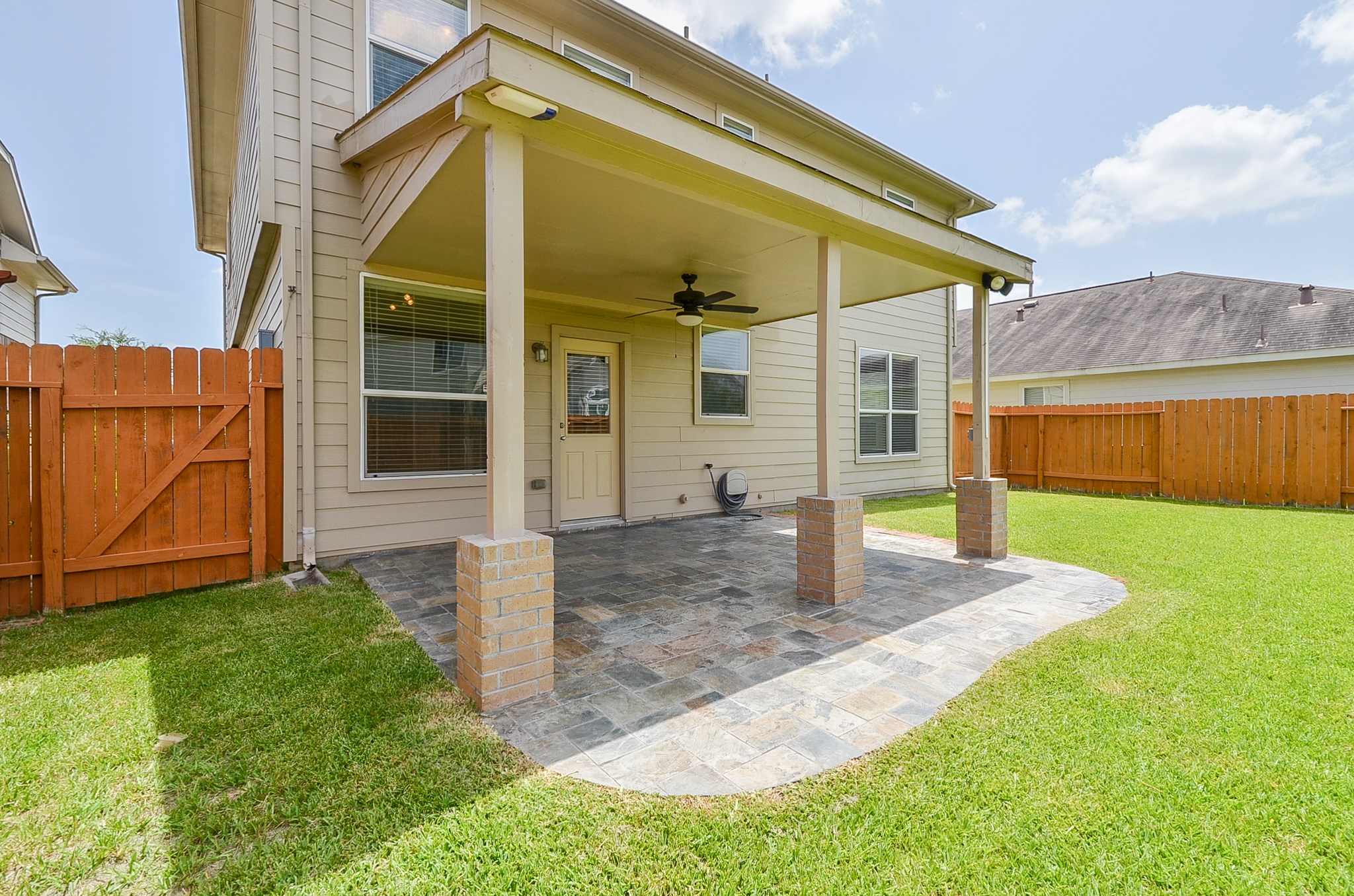 25135 Ginger Ranch Drive Katy, TX 77494 - Photo 30 of 32 The backyard connects seamlessly to a covered patio, creating a functional outdoor extension of the home.