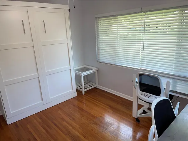 a view of a workspace with furniture and a window