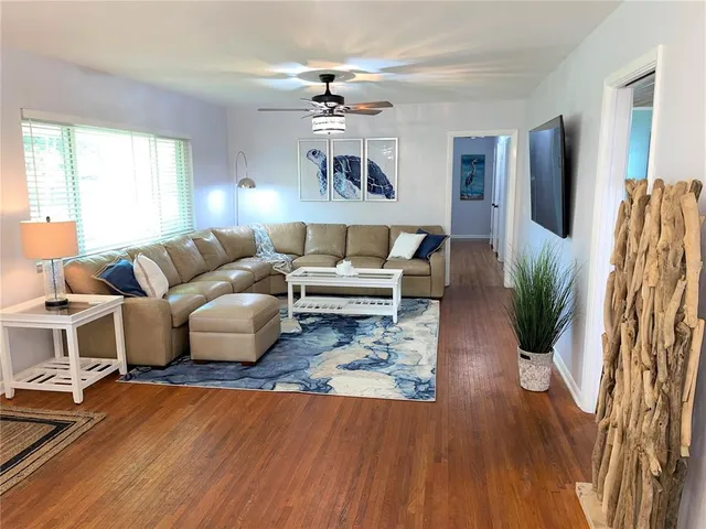 a living room with furniture and a wooden floor