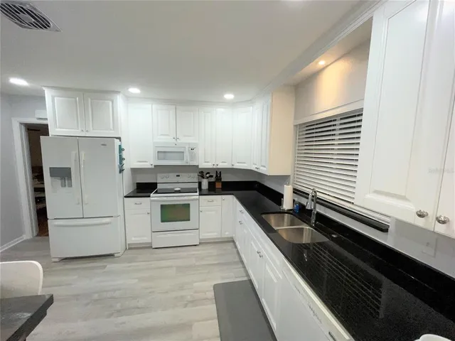 a kitchen with a sink a counter top space stainless steel appliances and cabinets