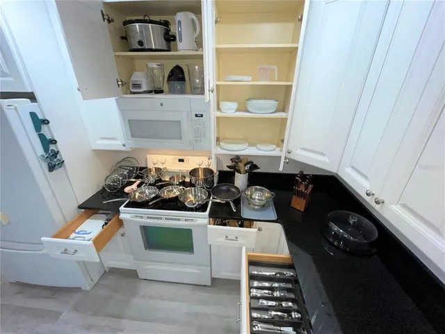 a kitchen with a stove and white cabinets