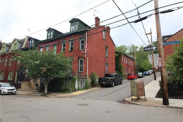 a view of a street with a cars parked in front of it