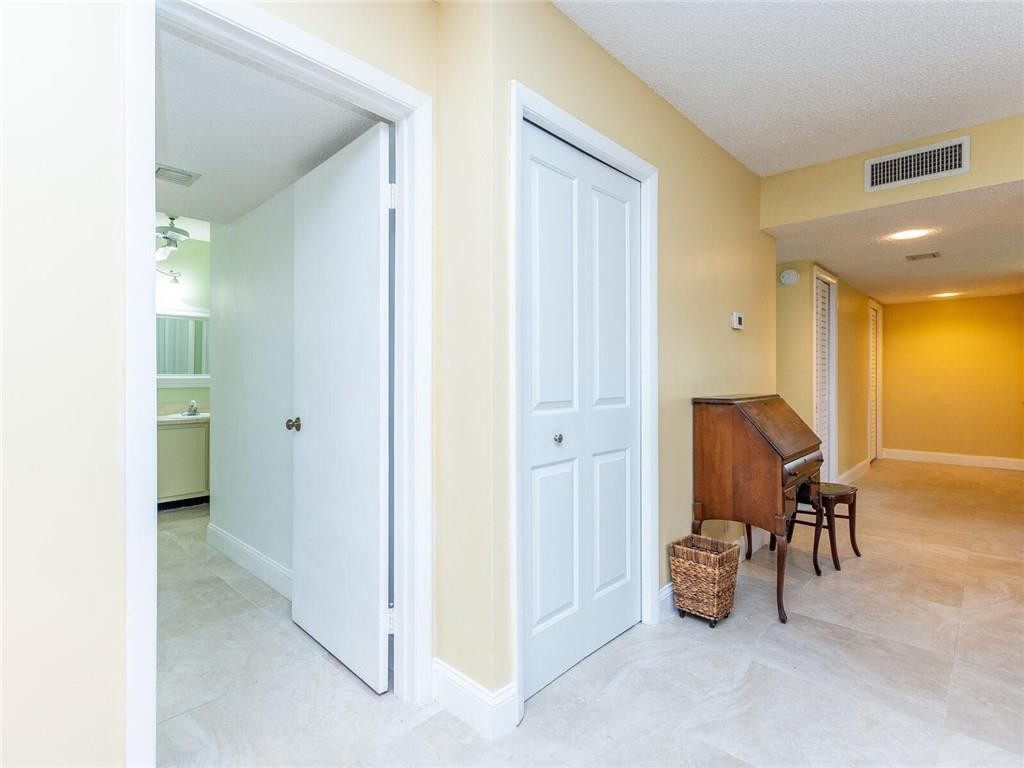 340 Racquet Club Road, Unit 103 Weston, FL 33326 - Photo 16 of 39 a view of a hallway with couch and a bathroom