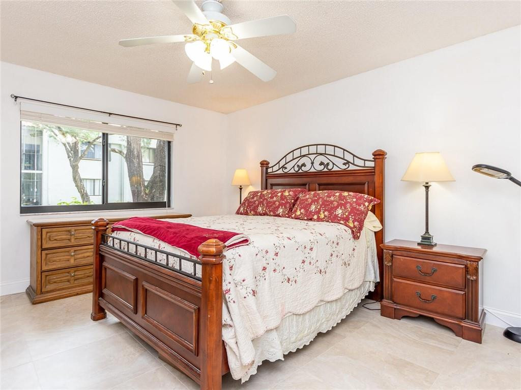 340 Racquet Club Road, Unit 103 Weston, FL 33326 - Photo 27 of 39 a bedroom with a bed and a dresser