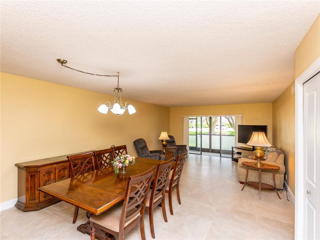 340 Racquet Club Road, Unit 103 Weston, FL 33326 - Photo 8 of 39 a view of a dining room with furniture and a chandelier