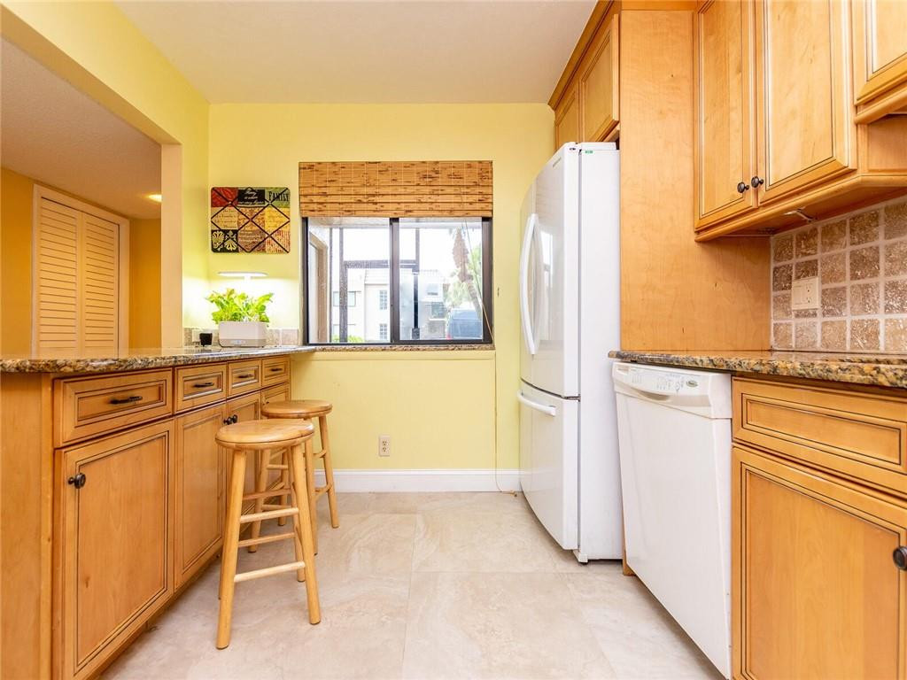 340 Racquet Club Road, Unit 103 Weston, FL 33326 - Photo 9 of 39 a view of a kitchen with a table and chairs