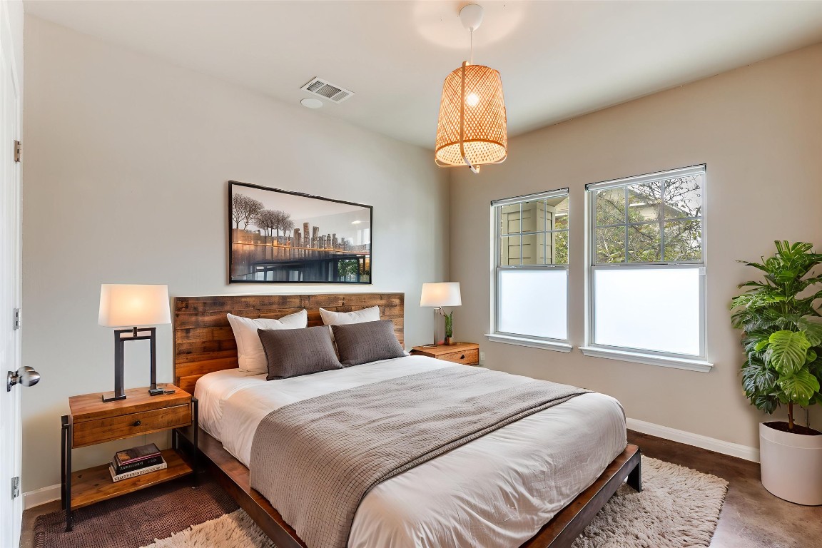 4607 Truth Way, Unit 440 Austin, TX 78725 - Photo 11 of 30 a bedroom with a large bed and a potted plant