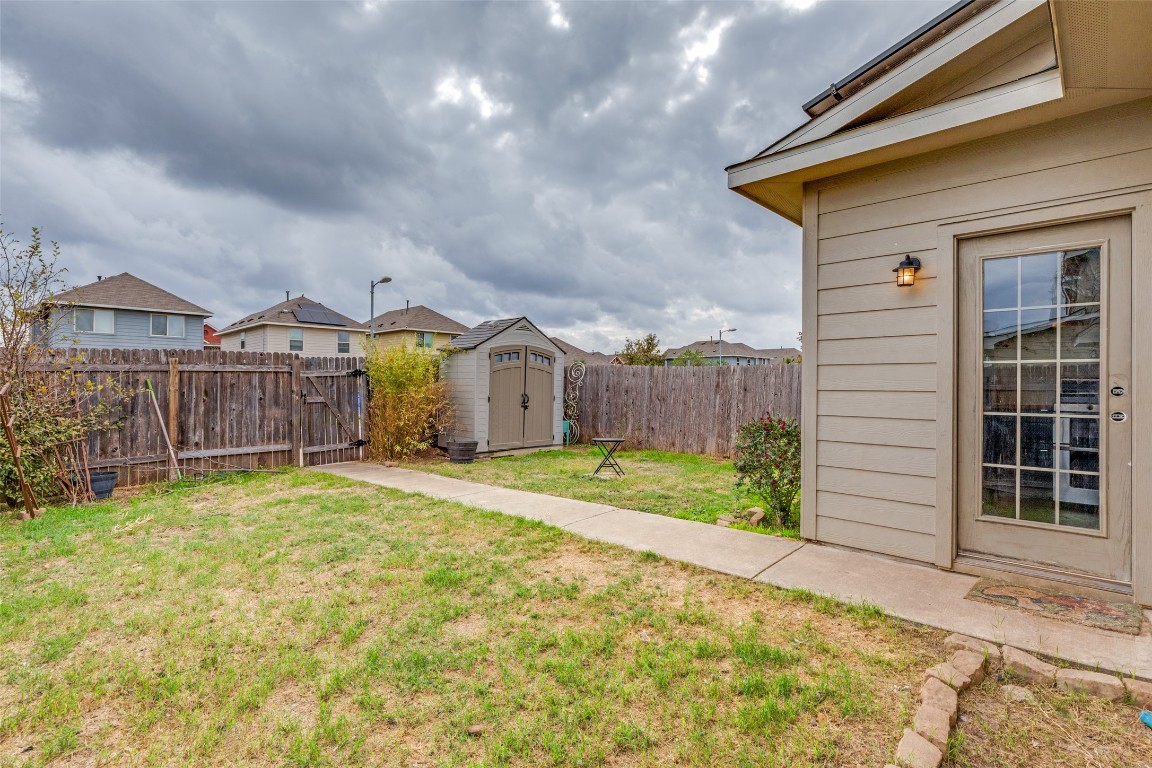 4607 Truth Way, Unit 440 Austin, TX 78725 - Photo 26 of 30 a view of a house with a yard and wooden fence