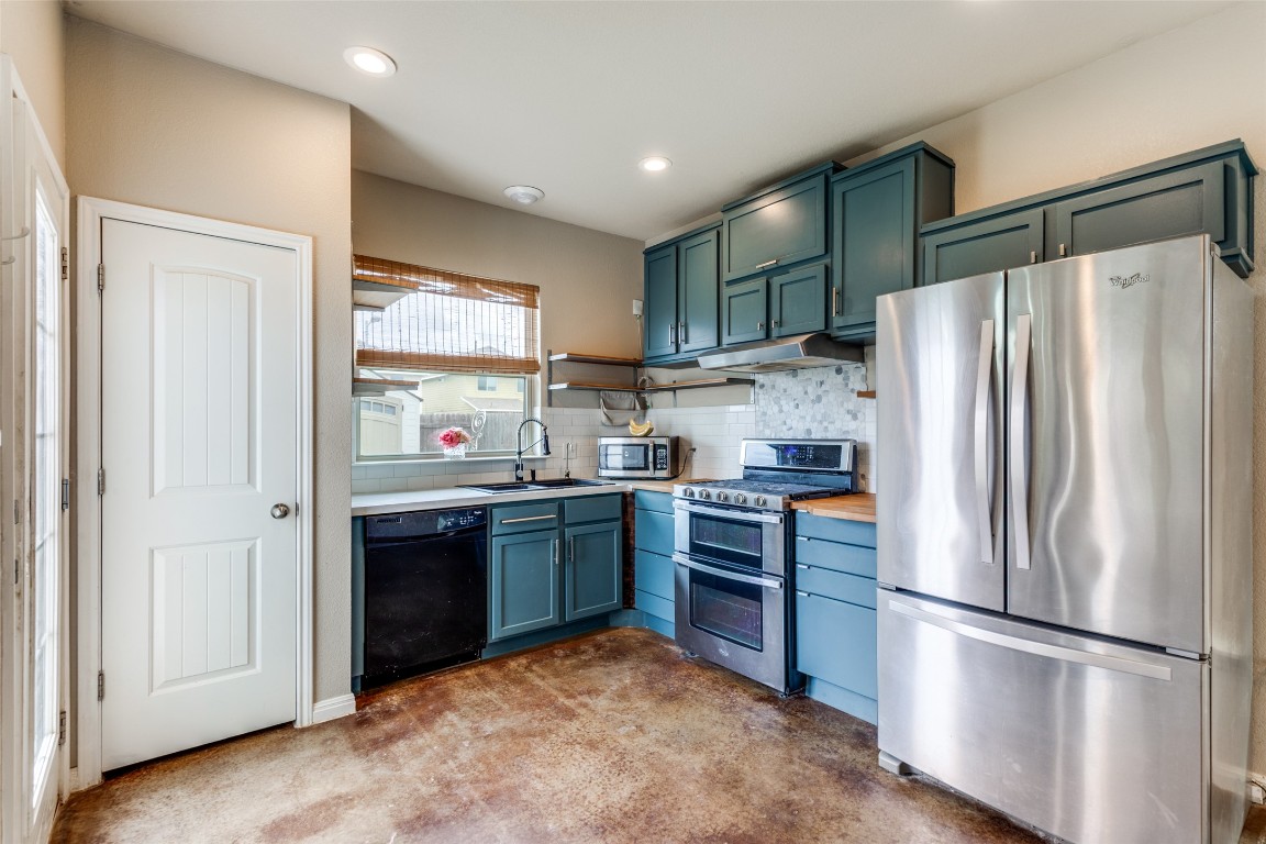 4607 Truth Way, Unit 440 Austin, TX 78725 - Photo 9 of 30 a kitchen with stainless steel appliances granite countertop a refrigerator and a stove top oven