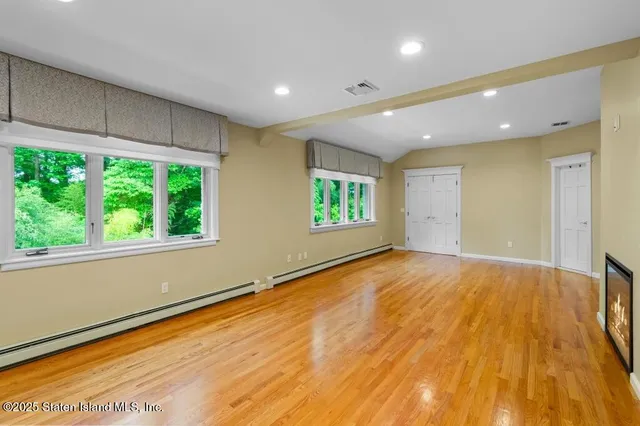 a view of empty room with wooden floor
